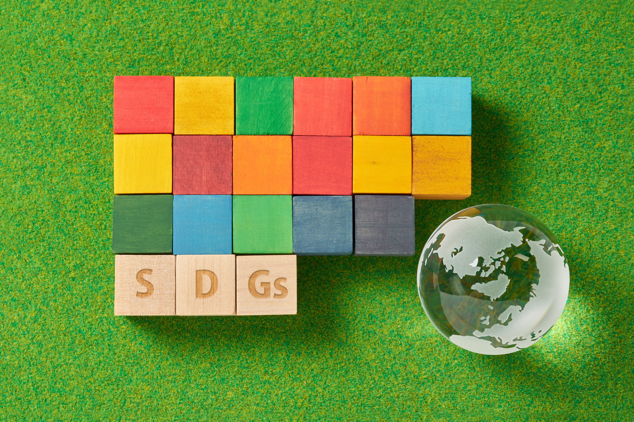 globe and a wooden cube stamped with the letters SDGs.