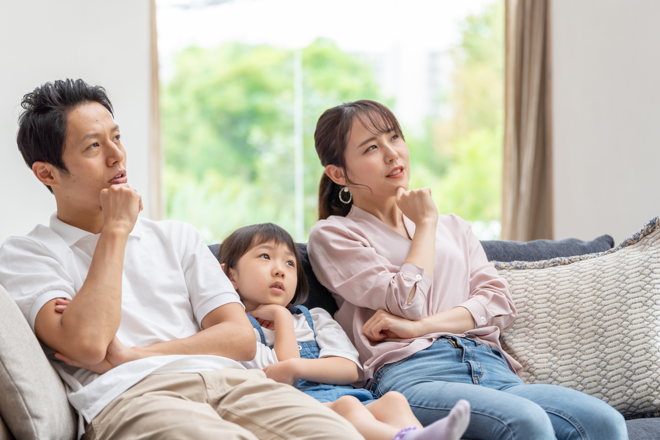 young japanese family thinking on the sofa